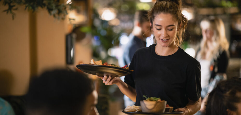 A waitress serving customers food at a restaurant in Newcastle-Upon-Tyne.